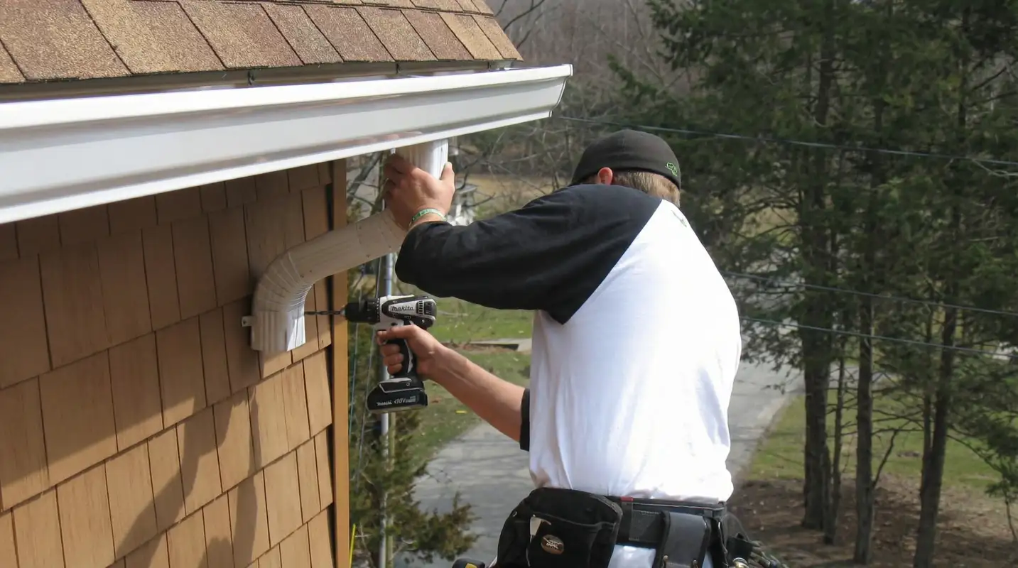 Professional contractor installing tan vinyl siding panels on a residential home exterior in Norfolk, VA